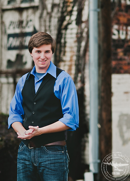 high school senior boy with brick wall in the background near plano texas