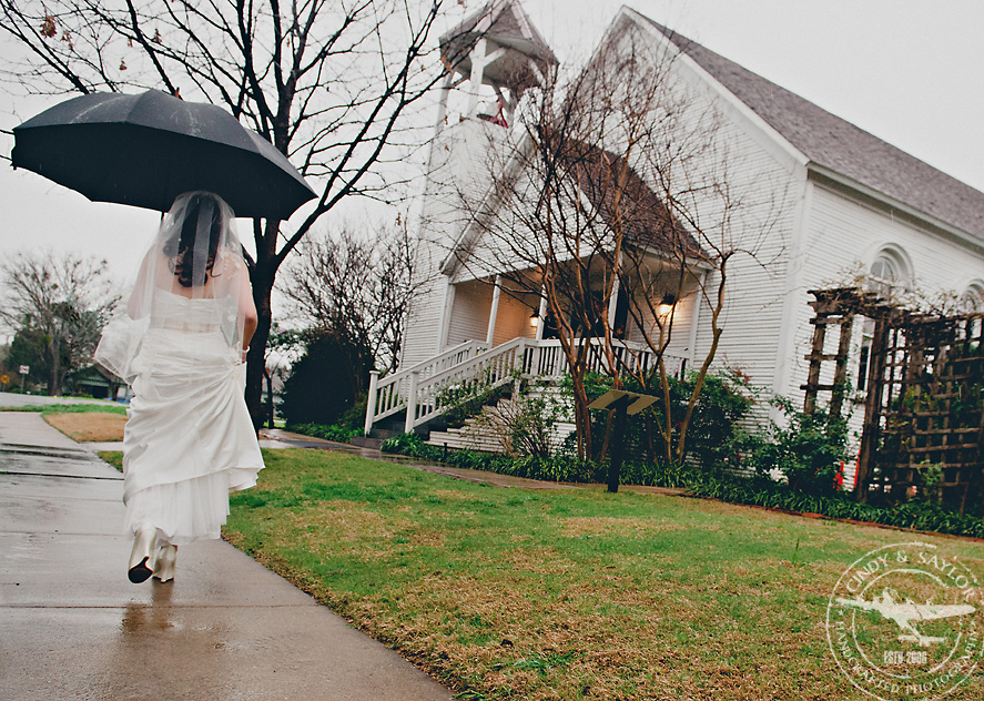 bride going to ceremony in the rain in front of a historic chapel in mckinney texas