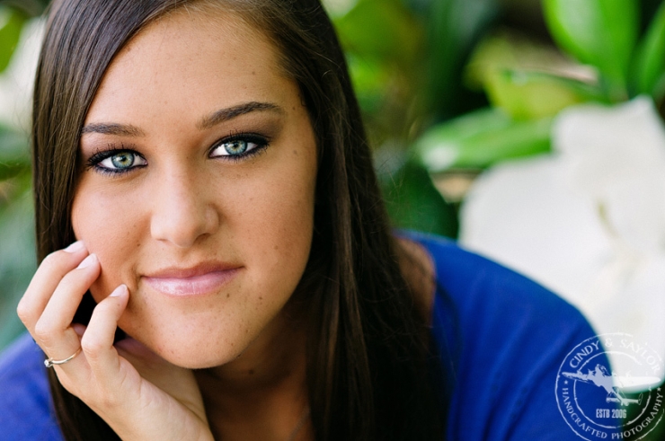 plano high school senior in bright blue in front of a magnolia tree at the dallas arboretum